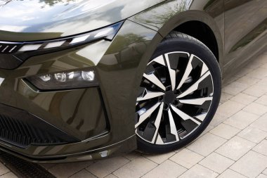 Yeni elektrikli araç ön tekerleği. Modern elektrikli araba tekerleği. Yolda lastikleri kapat. Araba lastiklerinin ayrıntıları yolda. Farlar kapanıyor araba LED farlar kapanıyor.