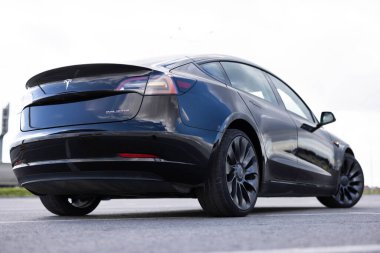 Lviv, Ukrayna - 16 Ekim 2025: Sergi salonunda Siyah Tesla Model 3 elektrikli araba, çağdaş Avrupa 'da EV kullanımındaki eğilimler, otomotiv endüstrisindeki son teknolojiler, çevresel sürdürülebilir.