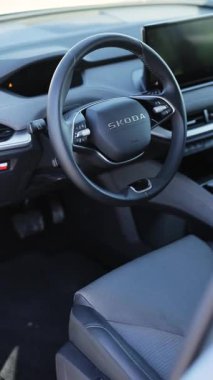 Yeni 2025 Skoda ENYAQ 85 elektrikli aracının dikey videosu. Direksiyon simidi. Direksiyon simidi olan elektrikli bir araba. Gösterge paneli, iklim kontrolü, hız göstergesi, Lviv, Ukrayna - 4 Mart 2026