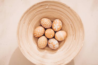 Minimalist kompozisyon. Tabakta paskalya yumurtası. Eko tarzı. Sıcak pastel tonlar. Yukarıdan görüntüle