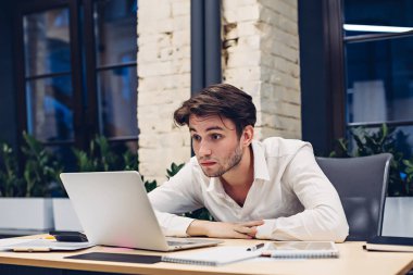 Şaşırtıcı iş adamı ofiste dizüstü bilgisayarla çalışıyor.