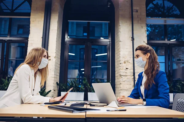 Sağlık maskeli iş kadınları ofiste çalışıyor.