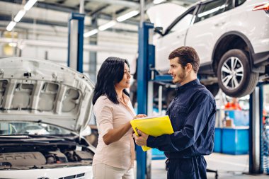 Otomobil tamirhanesi. Tamirci müşteriyle iletişim kurar.