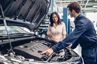 Araba servisi merkezi sahnesi. Tamirci müşteriyle iletişim kurar.