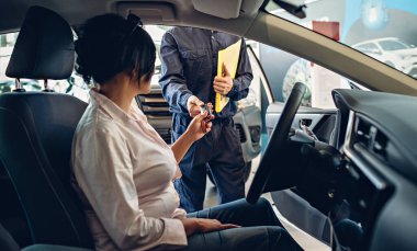 Araba servisi merkezi sahnesi. Tamirci müşteriye araba anahtarı verir