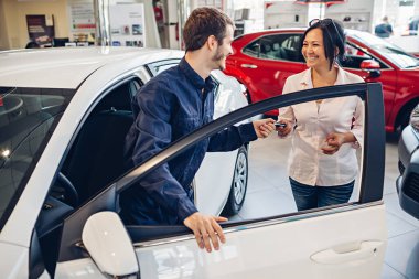 Araba servisi merkezi sahnesi. Tamirci müşteriye araba anahtarı verir