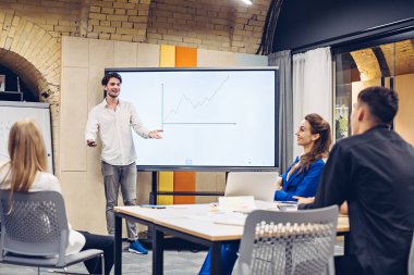 İş adamı iş arkadaşlarına büyüme grafiği gösteriyor