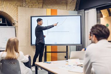 İş adamı iş arkadaşlarına büyüme grafiği gösteriyor