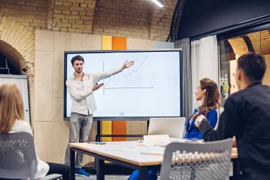 İş adamı iş arkadaşlarına büyüme grafiği gösteriyor