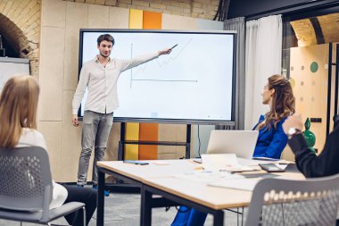 İş adamı iş arkadaşlarına büyüme grafiği gösteriyor