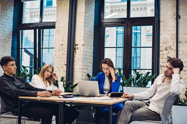 Ofisteki masaları düşünen üzgün iş adamları