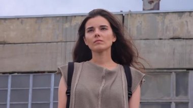 Bir arka plan endüstriyel harap binaların karşı hüzünlü güzel kız ayakta