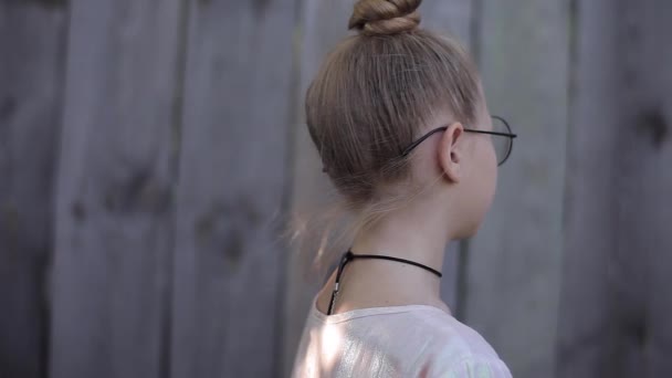 Vue du dos Fille dans une robe rose et un collier avec un coup de cheveux — Video