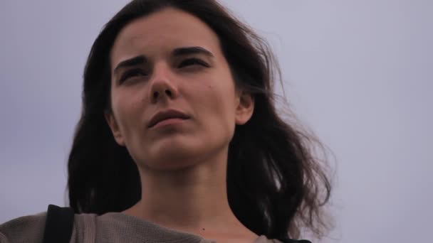 Kasvetli gökyüzü arka plan üzerinde üzgün esmer kadın portresi — Stok video