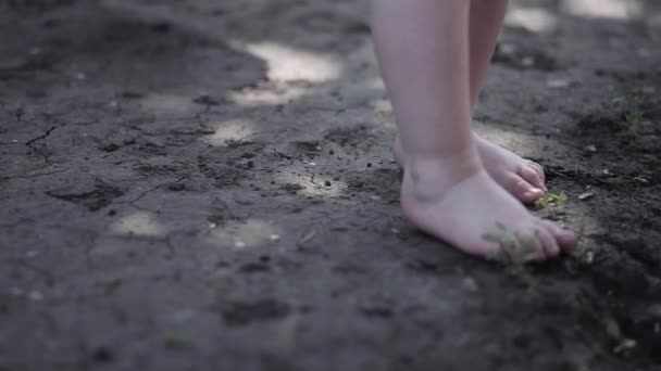 Baby pootjes maakt eerst lopen op blote voeten op de grond — Stockvideo