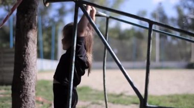 Asılı ve Bar üzerinde sallanan siyah elbiseli kız bebek