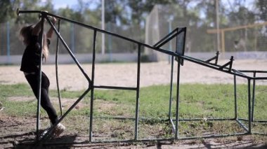 Küçük kız bir siyah ceket ve spor inşaat parkta oynarken tozluk