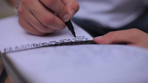 Mão do homem com marcador escreve texto no bloco de notas — Vídeo de Stock