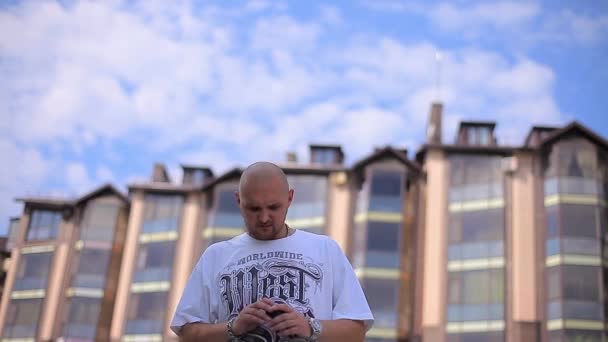 Nervous Man sta sullo sfondo di High-Rise Building e cielo e in attesa di qualcuno che gira intorno — Video Stock