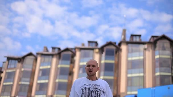 Rapper bianco Rapping sullo sfondo di un edificio a più piani — Video Stock