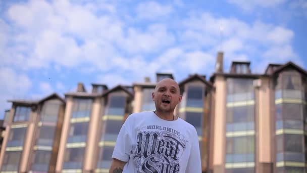 Mooie Rapper rappen in de buurt van het huis op een achtergrond van wolken — Stockvideo