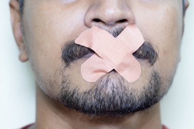 Ağzında bant ya da yara bandı olan adam sansürcüleri temsil ediyor.