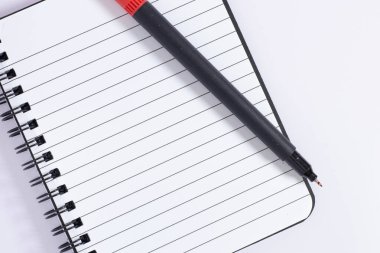 Sarmal notta kırmızı kalemle yazılmış bir notun yakın plan fotoğrafı.