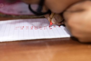 Kırmızı çizim kullanarak beyaz nota yazan çocuk sayısı