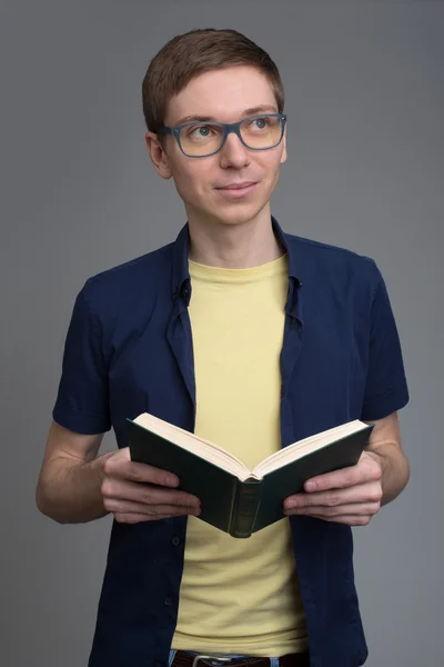 Junger Mann mit Brille liest ein Buch — Stockfoto