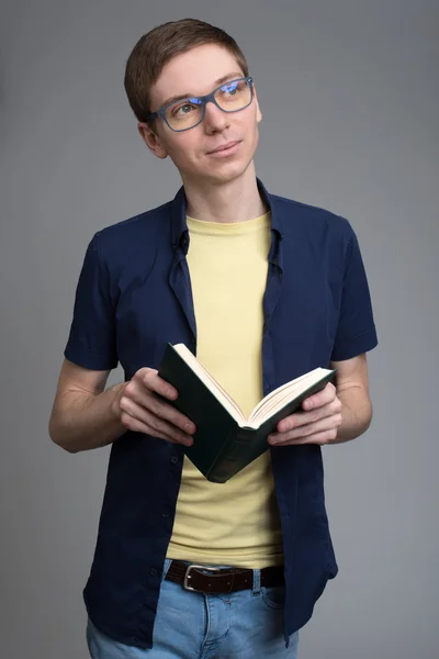 Jeune homme à lunettes lisant un livre — Photo