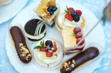 İçinde bir sürü kek, kek ve doğum günü pastası olan bir masa.