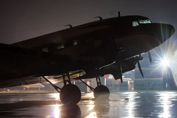 Retro vliegtuig op de regenachtige avond op de luchthaven — Stockfoto