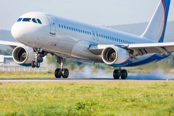 El avión aterriza. Tocando la pista con humo —  Fotos de Stock