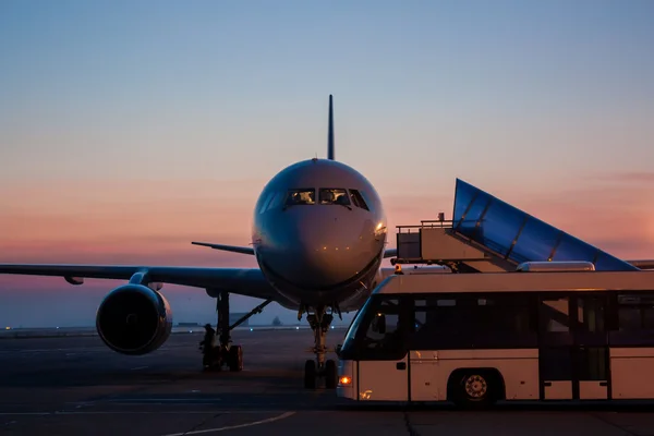 Aeronaves e ônibus no início da manhã avental do aeroporto — Fotografia de Stock