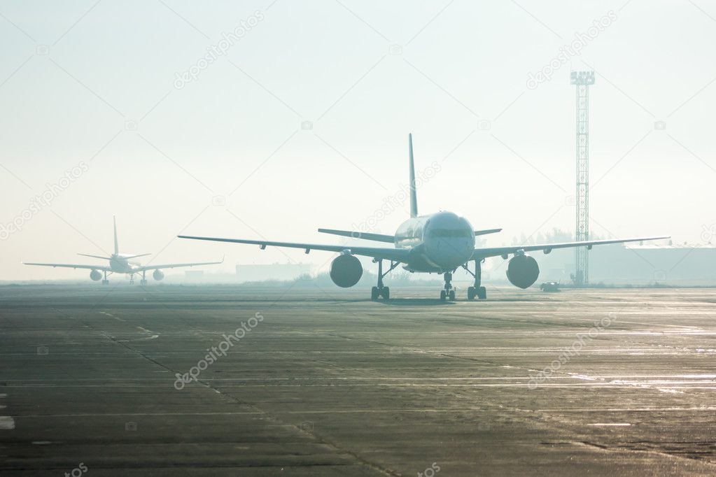 Airplanes in the fog on the airport apron