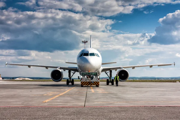 El tractor está remolcando el avión a un estacionamiento —  Fotos de Stock