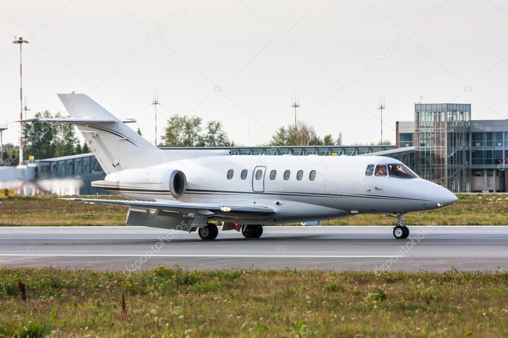 Business Jet on the runway in front of the airport terminal