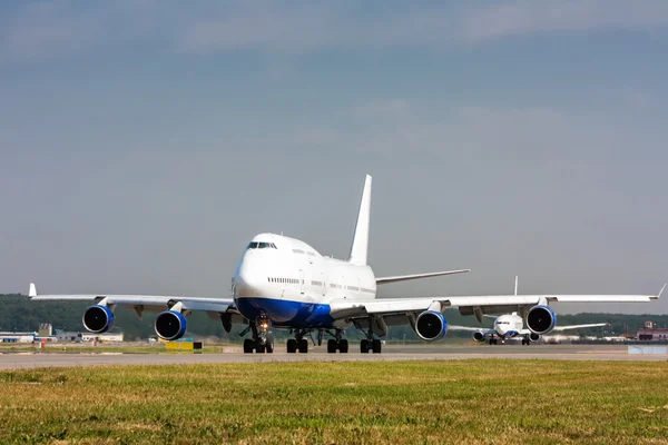 Aviones de cuerpo ancho que circulan en la pista principal y luego otro avión —  Fotos de Stock