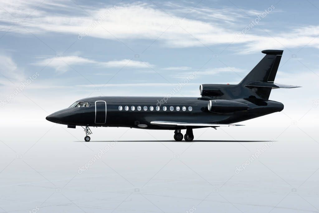 Modern black corporate business jet isolated on light background with sky