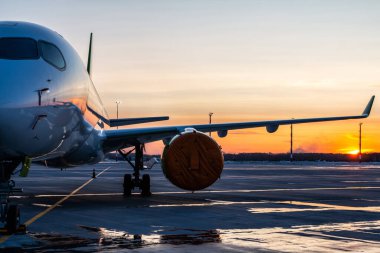 Günbatımının manzarasına karşı havaalanı önlüğü üzerinde modern yolcu uçakları