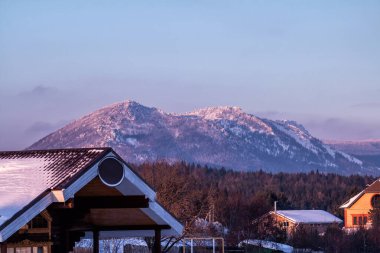 Dağlar, orman ve köy bir kış akşamı