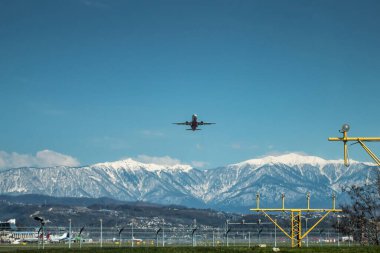 Yüksek manzaralı dağların arka planında bir yolcu uçağının kalkışı