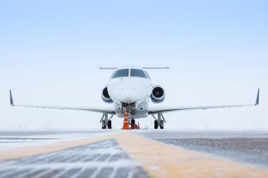 Beyaz lüks şirket jeti kış havaalanı önlüğünün üstünde.
