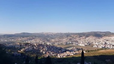 Kuzey Fas 'taki Tetouan şehrinin tam bir manzarası. Bu yüksek noktadan itibaren, beyaz cepheler altın güneş ışığıyla ısınan yuvarlanan tepelerin üzerine saçılmış inciler gibi parıldıyor.