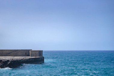 Okyanus ve mavi gökyüzü üzerinde taş liman