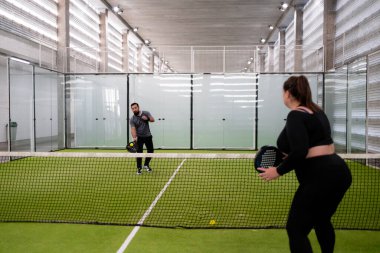 Spor giyimli beyaz yetişkinlerle kapalı kürek tenisi maçı. Yüksek kalite.