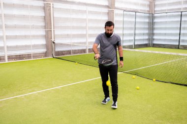 Erkek yetişkin, yeşil sahada kürek tenisi oynuyor. Yüksek kalite.