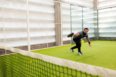 Erkek sporcu, sahada raket ve topla pikap oynuyor. Yüksek kalite.