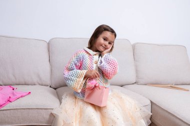 Kanepede renkli süveter ve tül etekli beyaz bir kız. Yüksek kalite.