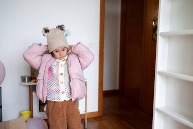 Kışlık paltolu ve şapkalı beyaz bir kız çocuğu. Yüksek kalite.